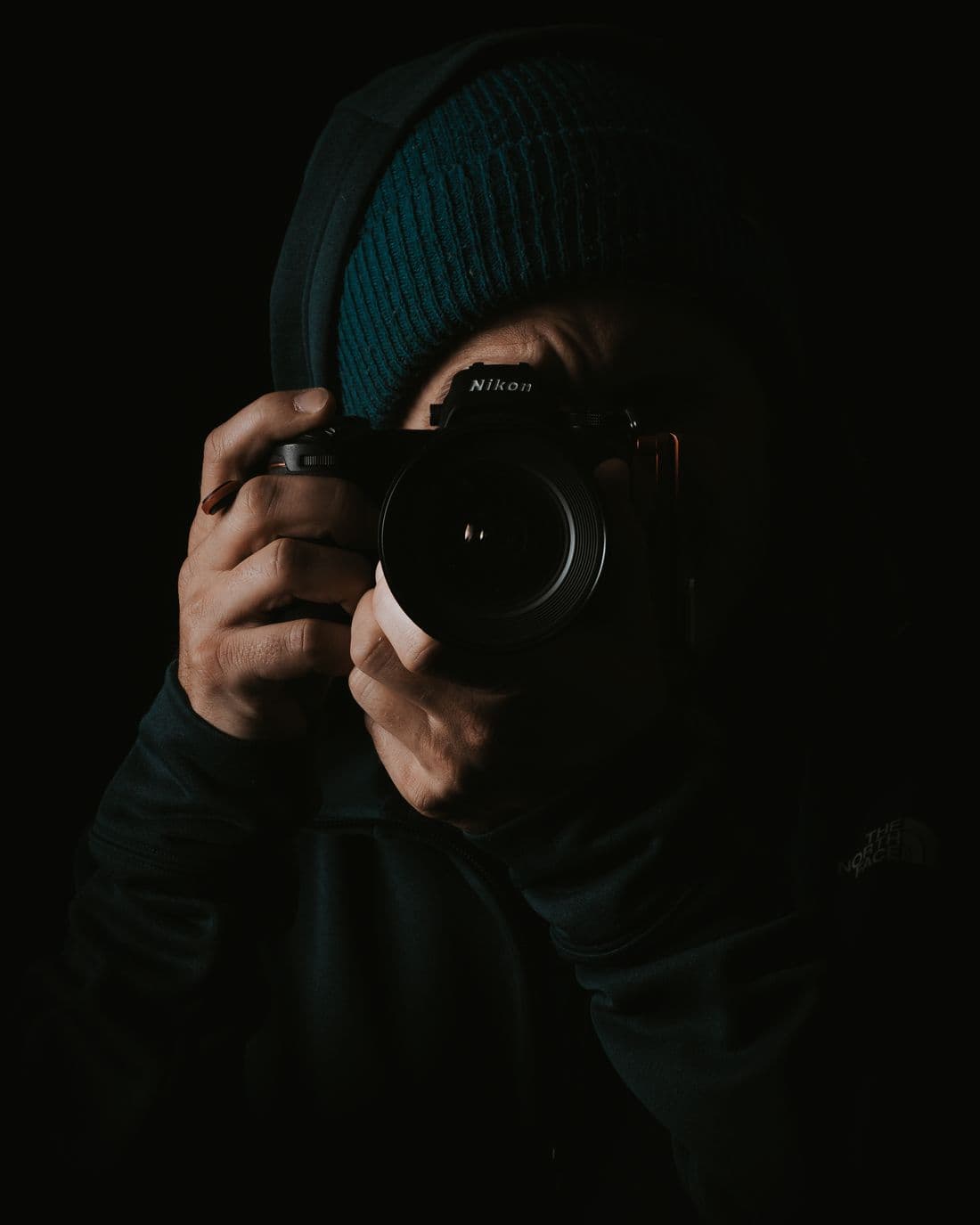 Photographer framing a shot in a dark studio