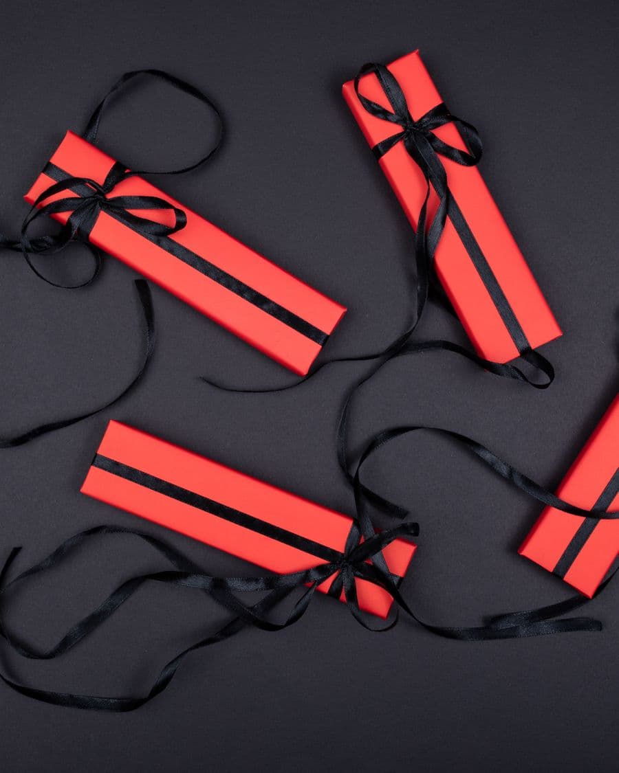 Gift boxes tied with black ribbon photographed from above on black