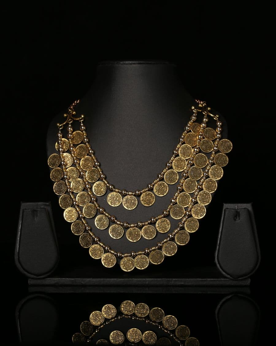 Gold necklace styled on a black product backdrop