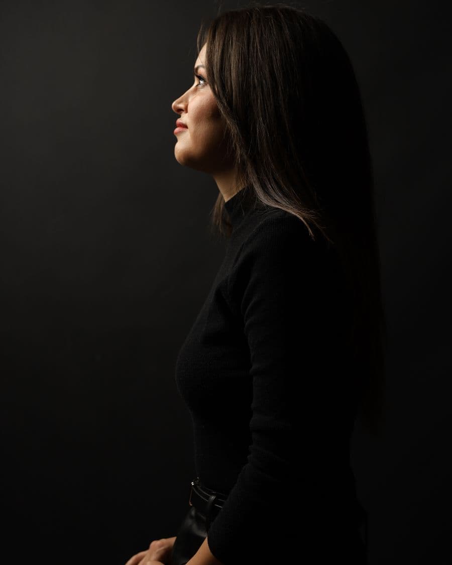 Side profile studio portrait against a dark backdrop