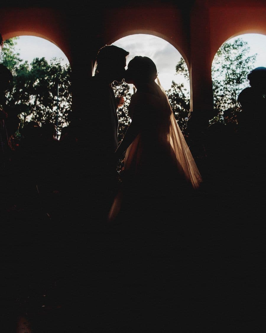 Newlyweds silhouetted against darkness